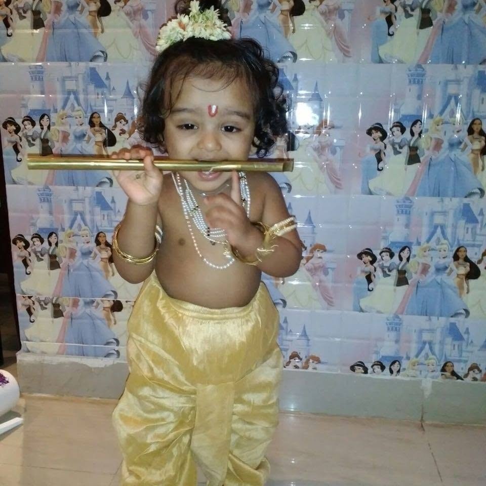 Raman dressed as little Krishna with a golden flute